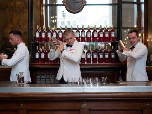 Profesionálni barmani miešajúci Campari drinky